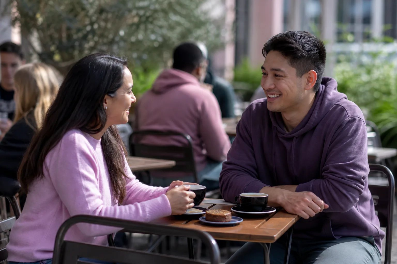 Two people talking over coffee beside Torquay harbour
